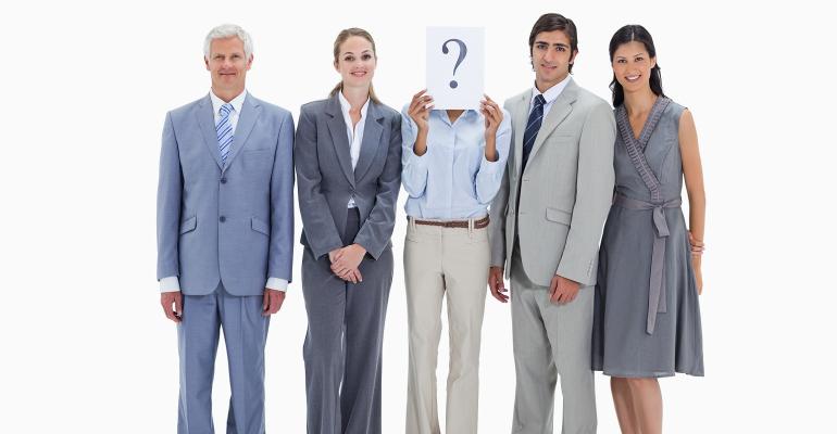Work team with one employee holding question mark in front of face