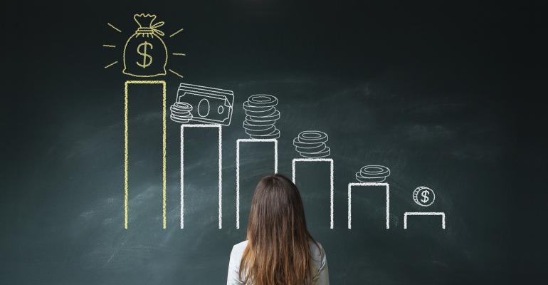 Businesswoman standing in front of a blackboard with a financial chart